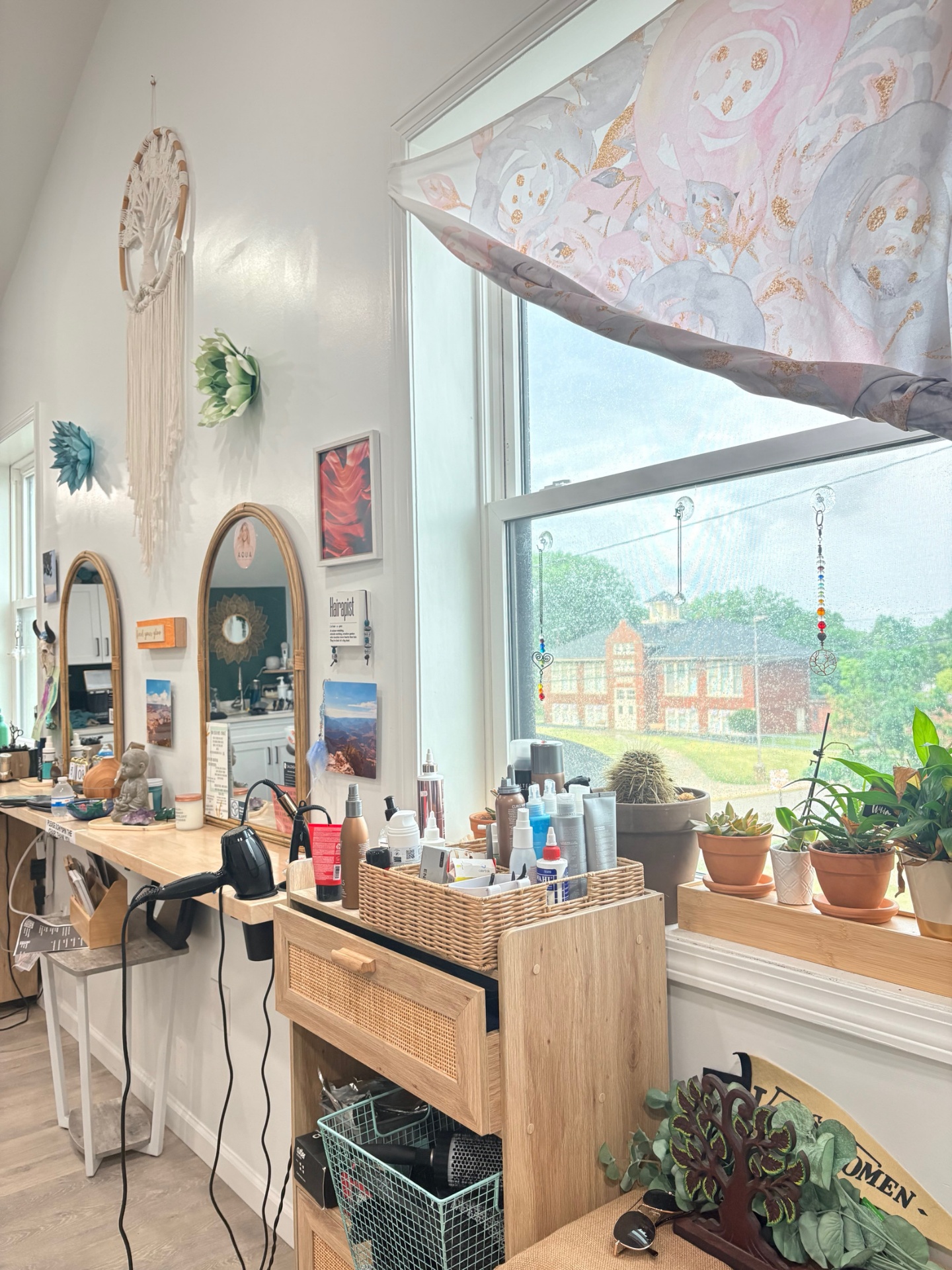 Inside BBStyle Studio: rattan arched mirrors, macramé wall hanging, sunlit window with plants and crystal suncatchers